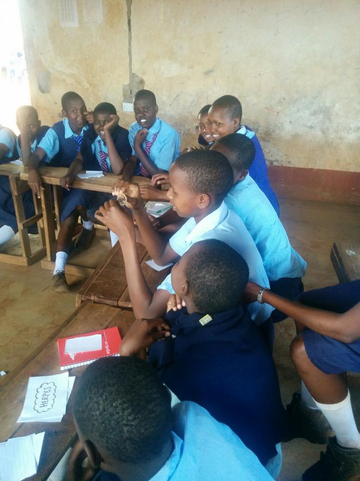 A group of school children in Kenya receive a condom demonstration by Go Health Fellow Alisha Wang Condom demonstration