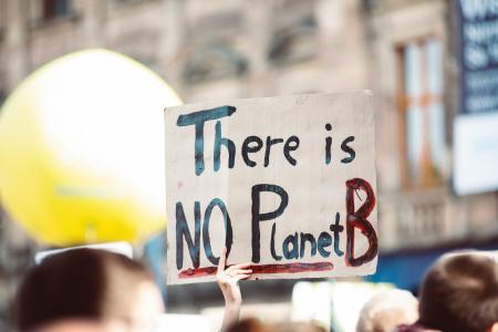 Hand holding a sign that reads: There is No Planet B