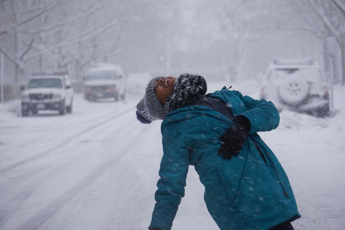 Nolawit leaning back and looking up at the snowfall.